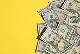 Large amount of cash on yellow background