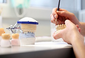 Longview Dentures person sculpting teeth model