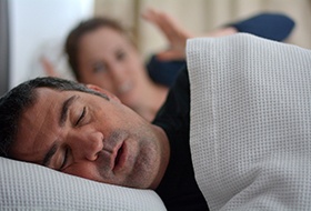 Man on his side snoring with sleep apnea in Longview, TX