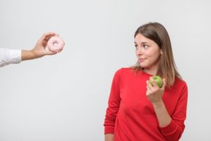 woman rejecting sweets and choosing healthy food